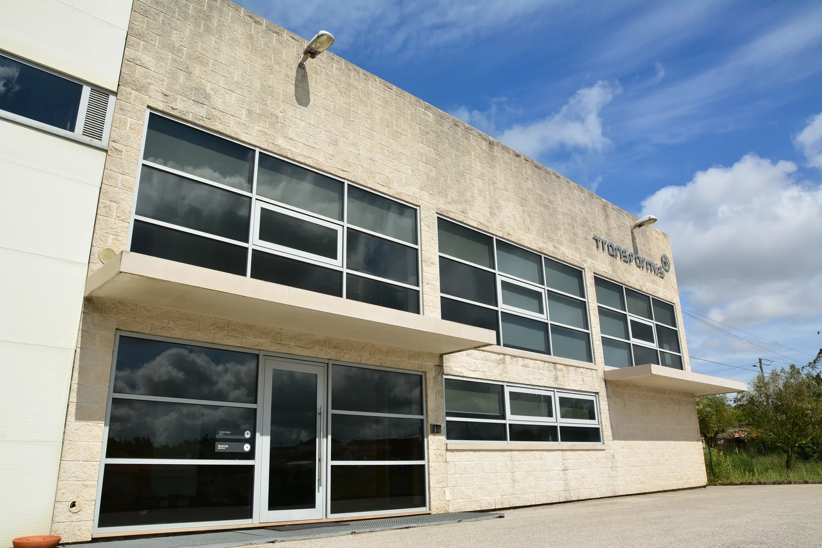 Exterior das instalações com o nome TRANSFORMIS na fachada